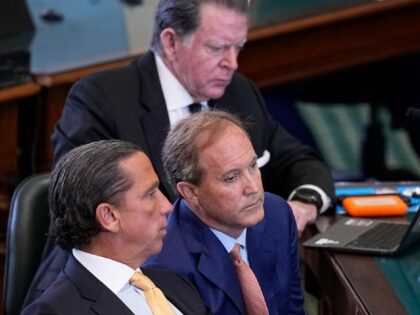 Texas state Attorney General Ken Paxton, center, sits with his attorneys Dan Cogdell, rear