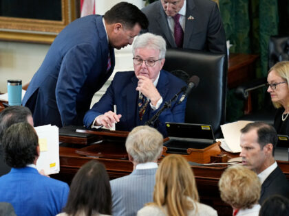 Texas Lt. Gov. Dan Patrick, center, talks with defense counsel and prosecution counsel dur