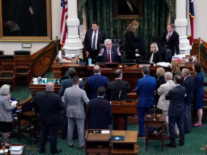 Texas Lt. Gov. Dan Patrick, seated center, talks to prosecution and defense attorneys afte