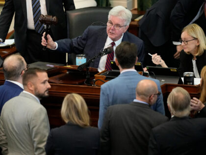 Texas Lt. Gov. Dan Patrick, center, strikes his gavel as he talks with defense and prosecu