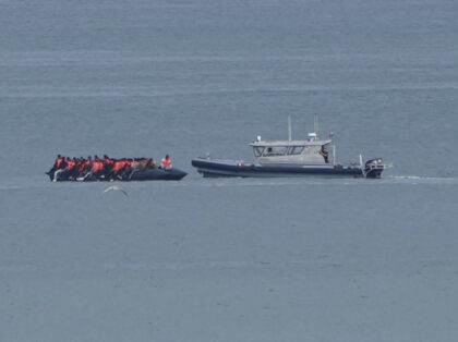 A boat thought to be with migrants is escorted by a vessel from the French Gendarmerie Nat