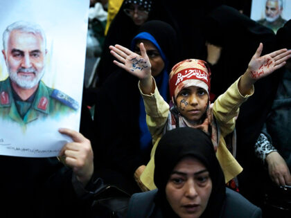 A girl holds up her hands with slogans reading in Farsi: "death to America" and "death to