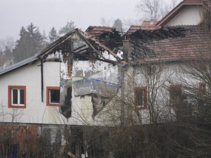 Police officers inspect a home for the elderly where eight people died in a fire, in Baraj