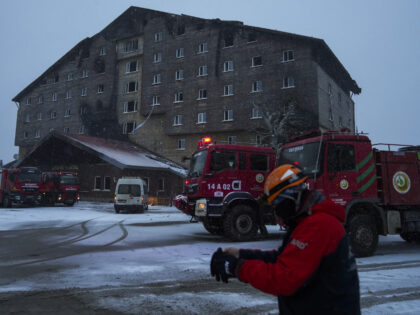 Firefighters and emergency teams work on the aftermath of a fire that broke out at a hotel