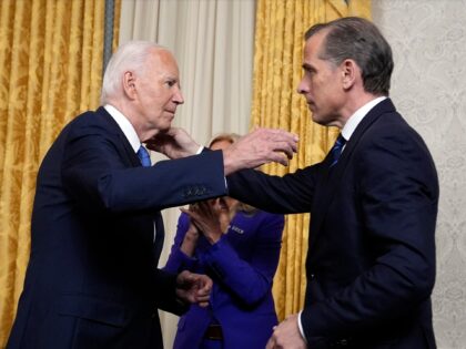 US President Joe Biden hugs his son Hunter Biden (R) after addressing the nation about his