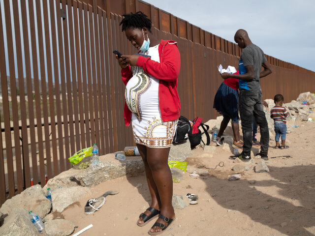 An immigrant family from Haiti waits to be taken into custody at the U.S.-Mexico border on