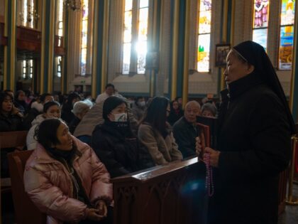 A sister speaks to attendees before a Mass at the Xishiku Catholic Church in on Christmas