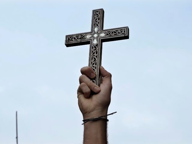 A Syrian Christian man holds u a cross in Damascus, Syria, Tuesday, Dec. 24, 2024, during