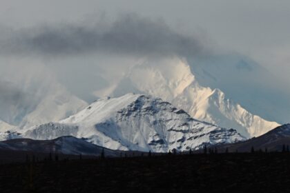 Clouds partially obscure Denali, the highest mountain peak in North America, as seen from