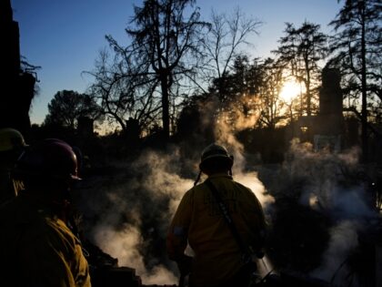 Firefighters put out a hot spot at a home destroyed by the Eaton Fire, Tuesday, Jan. 14, 2