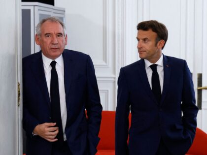 France's centrist Democratic Movement (MoDem) party leader Francois Bayrou (L) is escorted