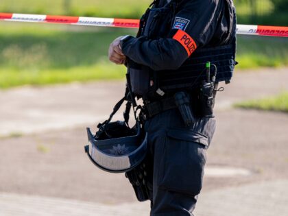 27 June 2024, Thuringia, Erfurt: A police officer stands in front of a police cordon near