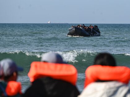 Migrants wait to board an already loaded smugglers' boat in order to attempt crossing the