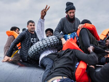 A migrant reacts after boarding a smuggler's inflatable dinghy in an attempt to cross the