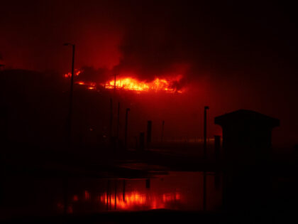 PACIFIC PALISADES, CA - JANUARY 07: A home burns in the Palisades fire above Pacific Coast