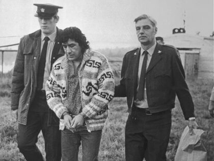 (Original Caption) Leonard Peltier, American Indian Movement leader, is led across Okalla