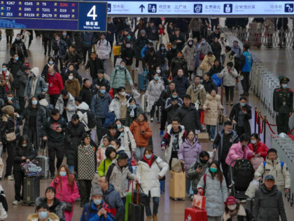 Travelers with their luggage arrive at a departure hall to catch their trains at the West