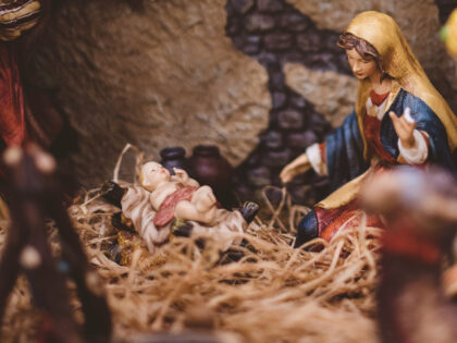 Manger scene depicting Mary watching over Baby Jesus in the manger (Ben White on Unsplash)