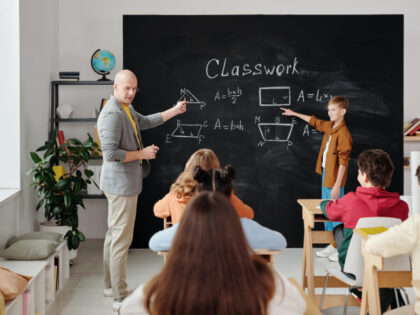 A teacher is doing math with his class (Pexels/Max Fischer).