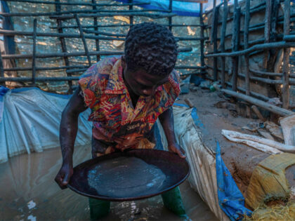 A young artisanal miner pans for gold in the sand at the Kamituga artisanal mine, in the S