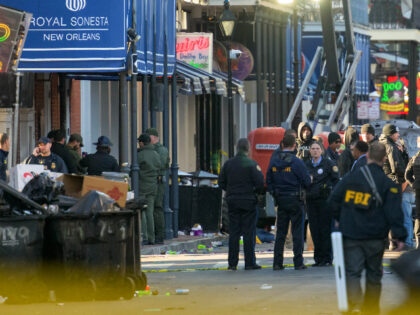 FBI investigators arrive at the scene where the white Ford F-150 pickup truck that crashed