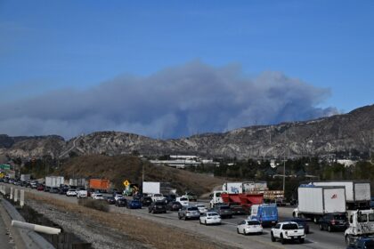 A plume of smoke is seen from the new fire, the Hughes fire, in the Sylmar neighborhood of