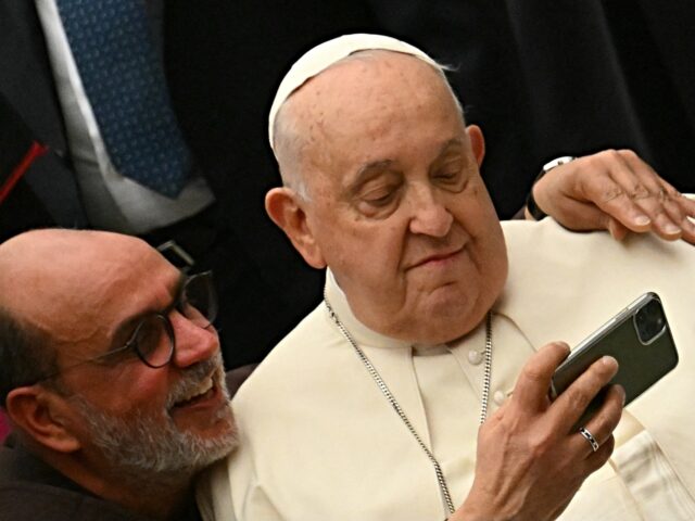 A father takes a selfie with Pope Francis during the Jubilee audience in the Paul VI hall