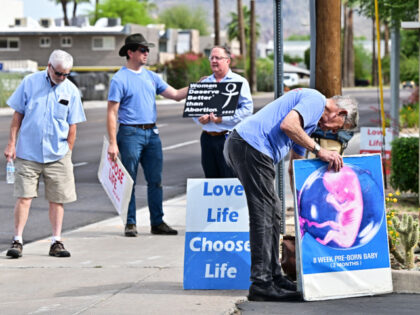 Pro-life activists place signs in front of Camelback Family Planning, an abortion clinic i