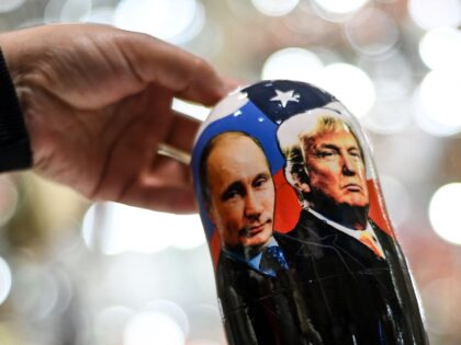 A vendor shows a traditional Russian wooden nesting doll, Matryoshka doll, depicting Russi