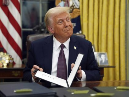 President Donald Trump signs executive orders in the Oval Office of the White House, Monda