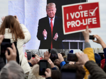 Pro-life demonstrators listen to US President Donald Trump as he speaks at the 47th annual