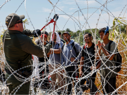 Border Patrol agent cuts razor wire border barrier place by Texas National Guard near Eagl