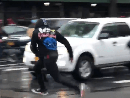 Protester flees from NYPD, nearly being struck by a car, after taunting officers. (Twitter